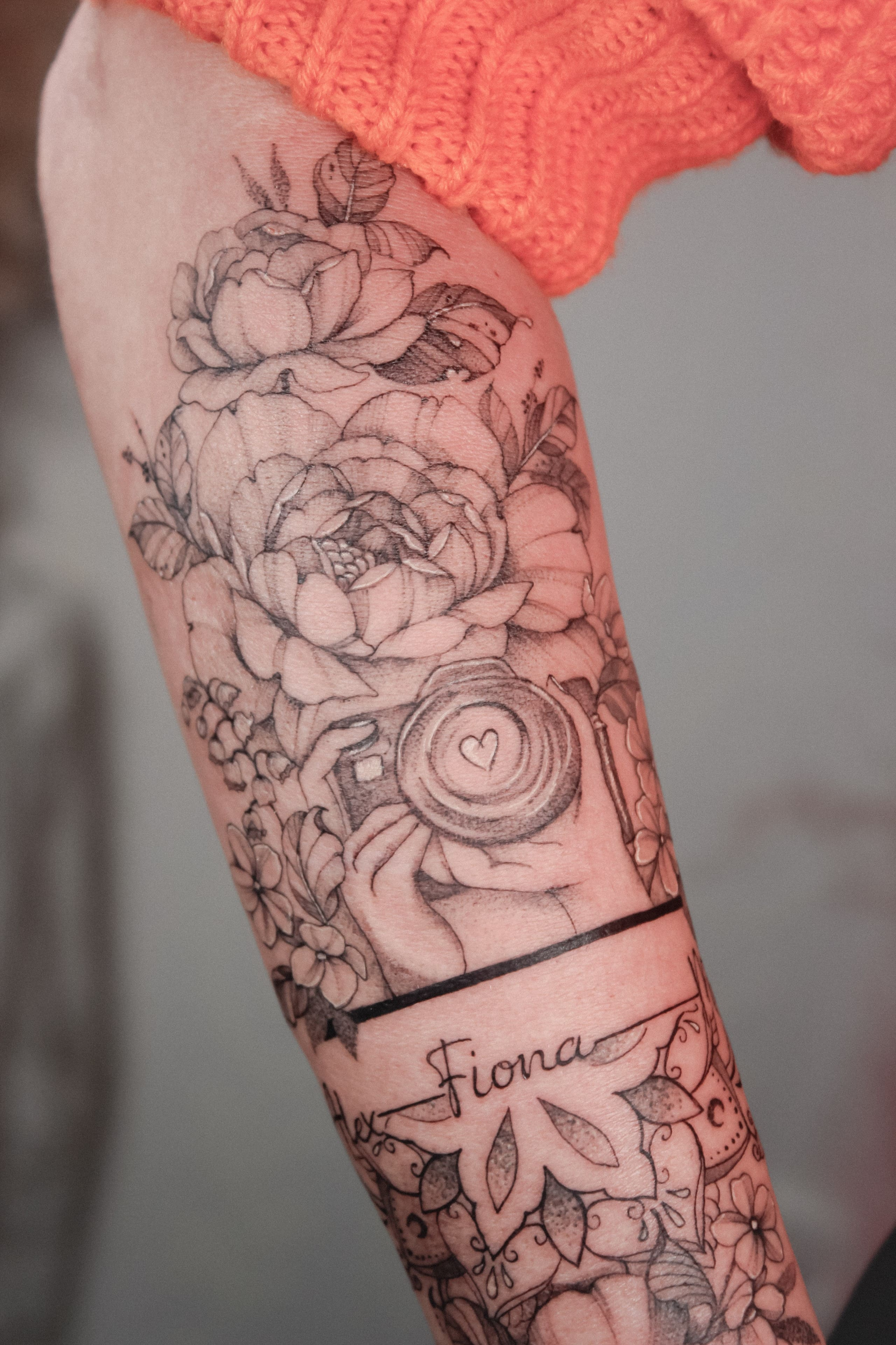 Kamera zwischen florales - Armtattoo